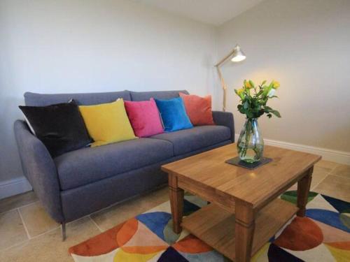 a living room with a blue couch with colorful pillows at Stunning location close to city centre - Pass the Keys in Bath