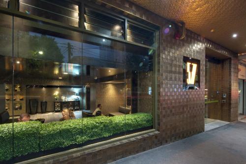 une fenêtre d'un restaurant avec des personnes assises dans l'établissement 57Hotel, à Sydney