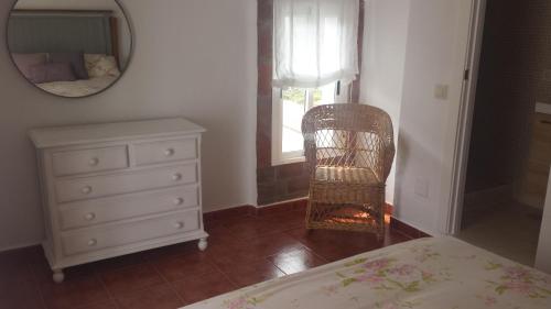 a bedroom with a bed and a dresser and a mirror at Casas Isabel in Zahora