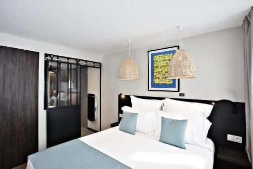 a bedroom with a bed with white and blue pillows at Boutique Hotel Villa du Taur in Toulouse
