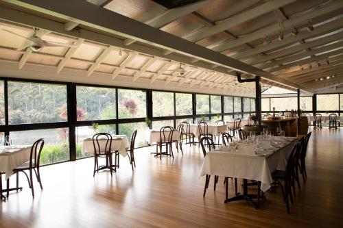 a banquet hall with tables and chairs and windows at Silkwood Estate in Pemberton