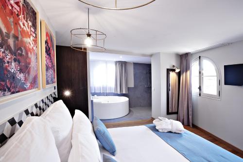 a bedroom with a large bed and a bath tub at Boutique Hotel Villa du Taur in Toulouse