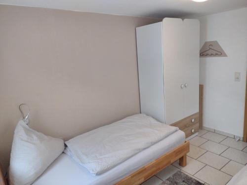 a small bedroom with a bed and a cabinet at Ferienwohnung Gersprenztal in Reichelsheim