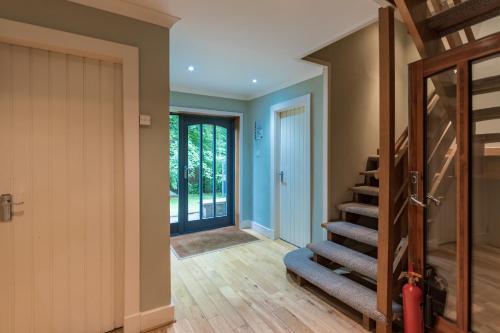 a hallway with a staircase leading to a door at LOCH TAY HIGHLAND LODGES and GLAMPING PARK in Morenish