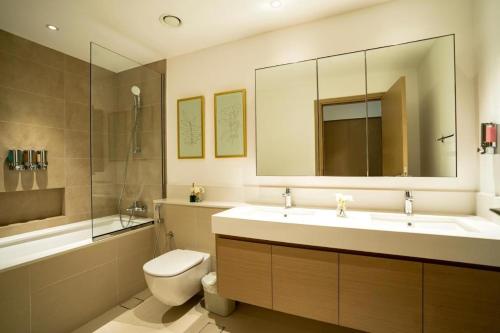 La salle de bains est pourvue d'un lavabo, de toilettes et d'un miroir. dans l'établissement Magnolia- Dubai Creek Harbour Condo Apartment ApartHotel UAE, à Dubaï
