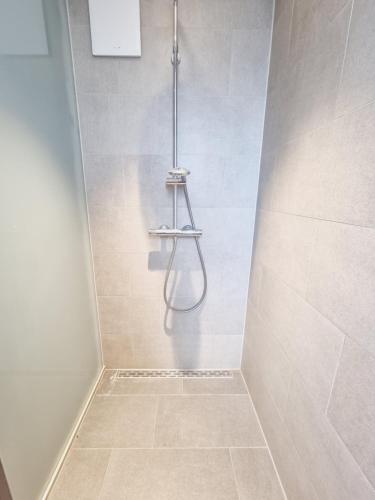 a bathroom with a shower with a hose in it at SKY HOME in Frankfurt/Main