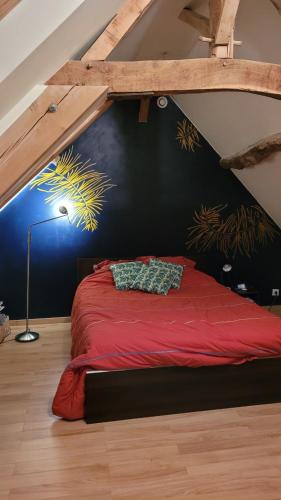 a bedroom with a red bed in a attic at CHAMBRE D'HOTE A 15 MIN DU CIRCUIT DES 24H DU MANS in Saint Pavace