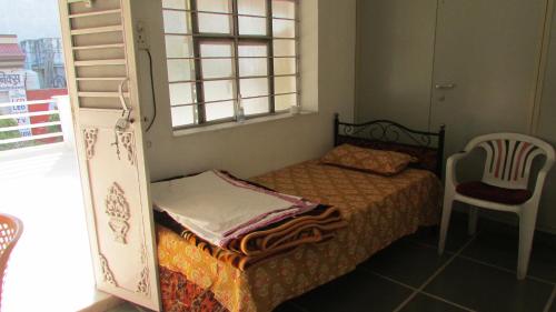 Habitación pequeña con cama y ventana en White Corner House, 2/14, Goverdhan Vilas, Housing Board Colony, Udaipur 313002, en Udaipur