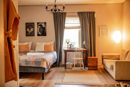 a bedroom with a bed and a chair and a window at Karkausmäen Kammari in Kinnula