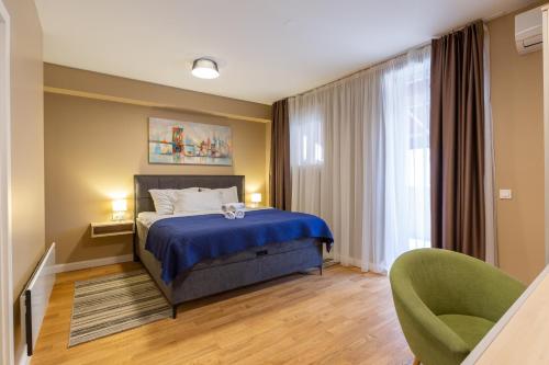 a bedroom with a blue bed and a green chair at Hotel Sky in Zadar