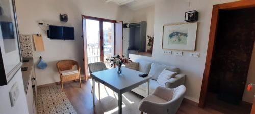 ein kleines Wohnzimmer mit einem Tisch und Stühlen in der Unterkunft AR28-1, Coqueto apartamento en primera línea de playa in Villajoyosa