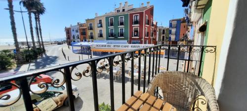 einen Balkon mit einem Stuhl und Straßenblick in der Unterkunft AR28-1, Coqueto apartamento en primera línea de playa in Villajoyosa