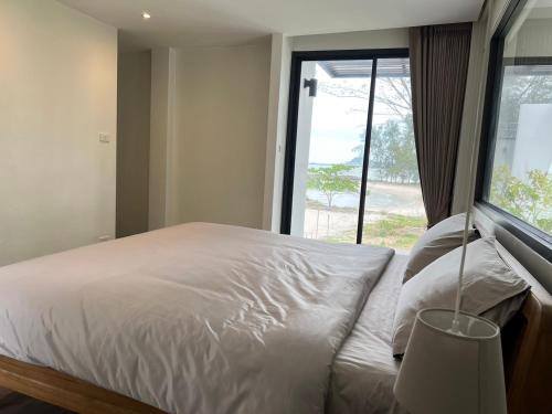 een slaapkamer met een wit bed en een raam bij Meet Up Villa 