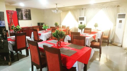 un comedor con mesas y sillas con mantel rojo en The Ambassadors Hotel en Lagos