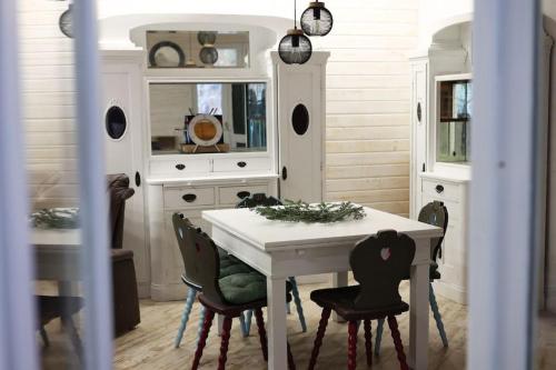 a dining room with a white table and chairs at Vila Relax Valiug Crivaia in Văliug