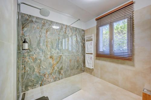 Baño con ducha a ras de suelo junto a una ventana en The View Aix-en-Provence, en Aix-en-Provence