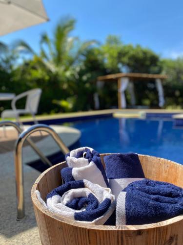 a basket filled with blue towels next to a pool at Costa do Sauipe Casa dentro do complexo hoteleiro in Costa do Sauipe