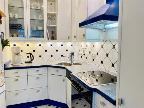 een keuken met witte kasten en blauwe en witte tegels bij Villa Caprivi 9 in Neuhof