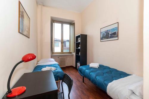 una camera con letto, scrivania e lampada rossa di Piazza Statuto Comfy APT - with 2 Balconies a Torino