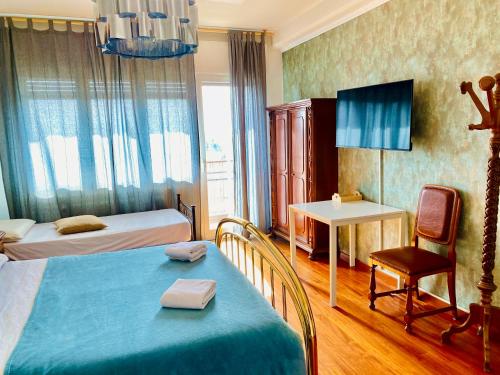 Un dormitorio con dos camas y una mesa y una silla. en Pang's Guesthouse, en Mestre