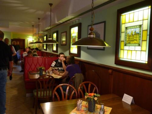 a group of people sitting at a table in a restaurant at Gasthof Zur guten Quelle in Schwerin