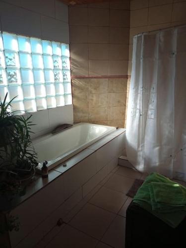 baño con bañera y ventana en Casa de huéspedes La vista en El Hoyo