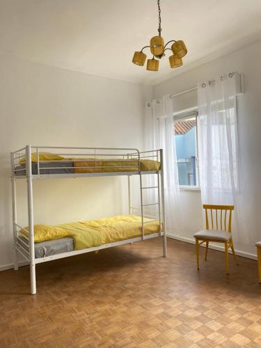 1 Schlafzimmer mit 2 Etagenbetten und einem Stuhl in der Unterkunft Barão 35 Guest House in Braga