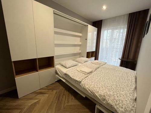 um quarto com uma cama e uma grande janela em Luksus w samym centrum em Breslávia