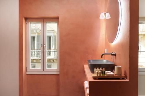 a bathroom with a sink and a window at Vittori Corfu Rooms in Corfu Town