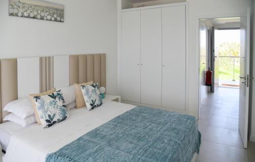 una camera bianca con un letto con una coperta blu di LUXURY OASIS SEA VIEW a Portimão