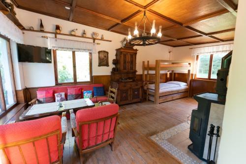 ein Wohnzimmer mit einem Tisch, Stühlen und einem Bett in der Unterkunft Edmundova chata in Jetřichovice