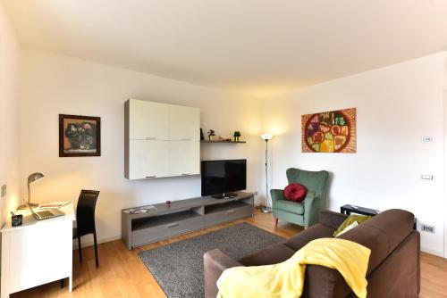ein Wohnzimmer mit einem Sofa und einem TV in der Unterkunft CaseOspitali - Casa Kikka elegante appartamento con balcone in nuovo condominio in Cernusco sul Naviglio