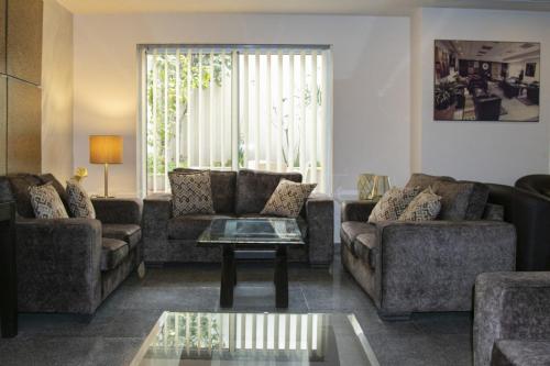 a living room with couches and a coffee table at Tamrah Suites Hotel in Amman