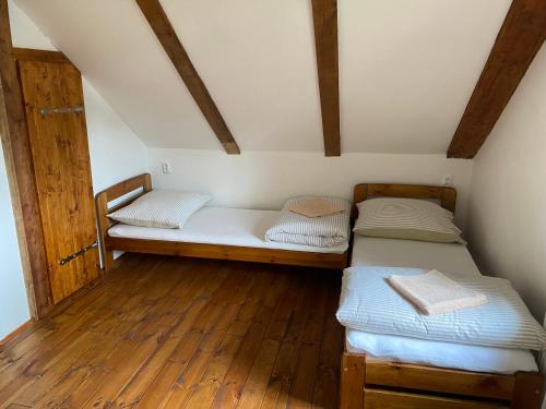 2 łóżka w pokoju z drewnianą podłogą w obiekcie Chata Pepina w mieście Růžová