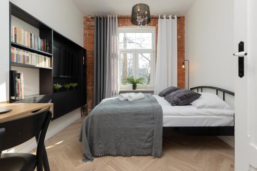een slaapkamer met een bed, een bureau en een raam bij Warsaw Pruszków Park View Comfortable Apartments by Renters in Pruszków