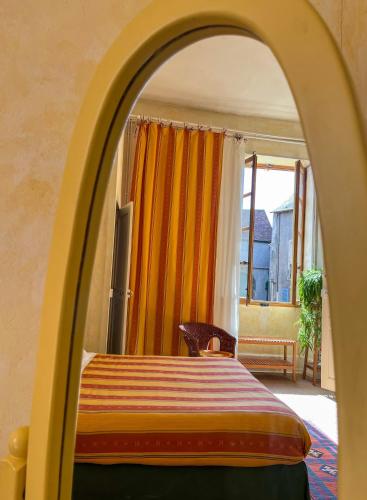 a bedroom with a bed with an arched doorway at Maison Sainte Barbe in Autun