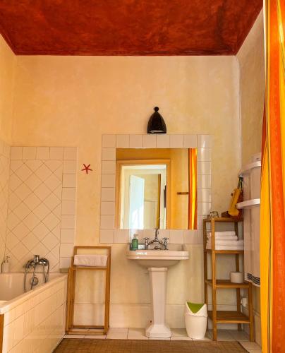 a bathroom with a sink and a tub and a mirror at Maison Sainte Barbe in Autun
