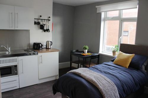 een keuken en een bed in een kleine kamer bij Superb Studio Flats in City Centre in Southampton