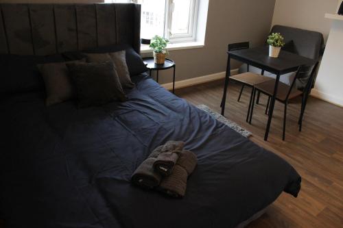 un letto con un asciugamano in una camera da letto di Superb Studio Flats in City Centre a Southampton