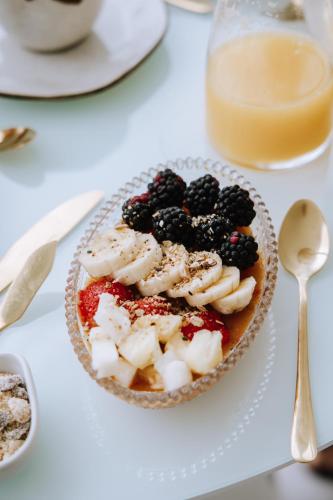 a bowl of fruit on a plate on a table at Olisa Hotel Boutique in Maresias