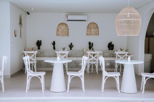 a white restaurant with white tables and stools at Olisa Hotel Boutique in Maresias