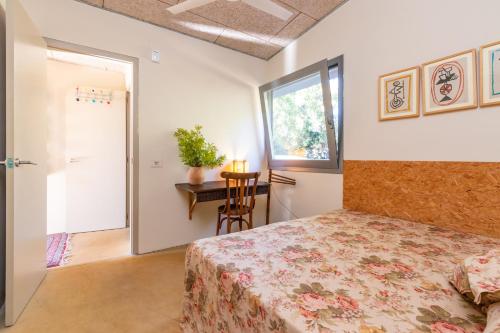 a bedroom with a bed and a table and a window at La casita del bosque in Vilopríu