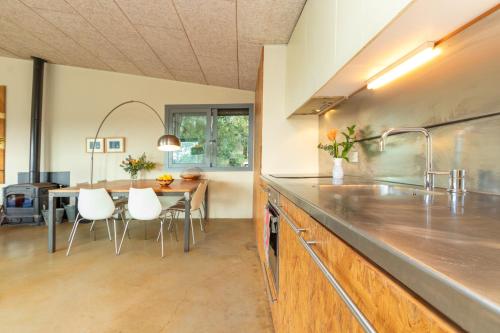 a kitchen with a table and a dining room at La casita del bosque in Vilopríu