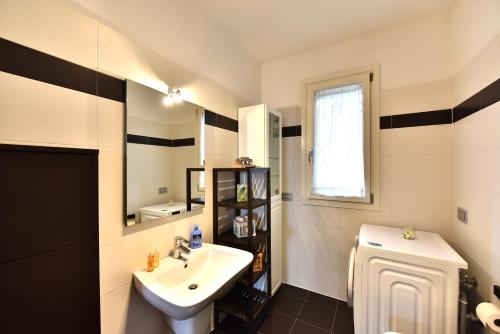 a white bathroom with a sink and a toilet at CaseOspitali - Casa Kikka, elegante appartamento con balcone in nuovo condominio per 4 in Cernusco sul Naviglio