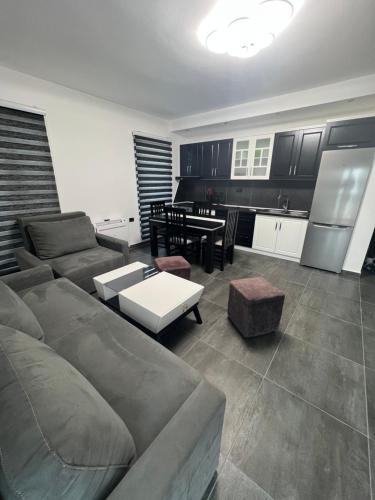 a living room with a couch and a kitchen at Dolce Italia Residence in Radhimë