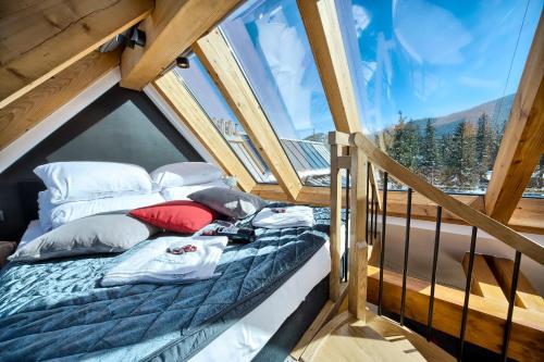 a bed in a room with a large window at VisitZakopane - Diamond Spa Apartment in Zakopane