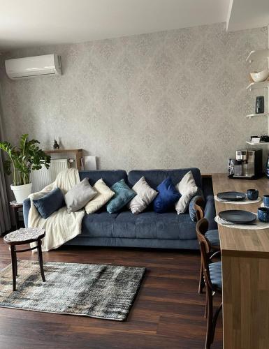 a living room with a blue couch with pillows at Niezapominajka przy Manufakturze in Łódź