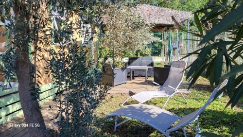 dwa krzesła i stół na dziedzińcu w obiekcie Chalet avec patio en Haute Corse 5 couchages w mieście Camp du Cap Sud