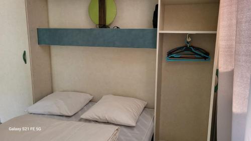 - łóżko piętrowe z 2 poduszkami w pokoju w obiekcie Chalet avec patio en Haute Corse 5 couchages w mieście Camp du Cap Sud