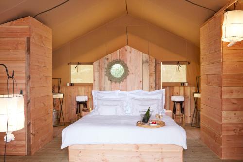 - une chambre avec un grand lit et un mur en bois dans l'établissement Château Léognan - Bordeaux - Nouvelle Ouverture, à Léognan